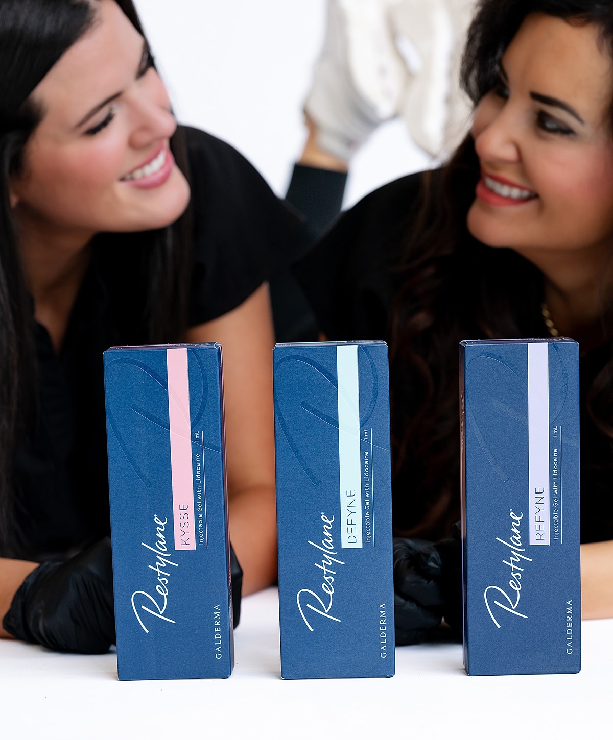 Two women with skincare products on display.