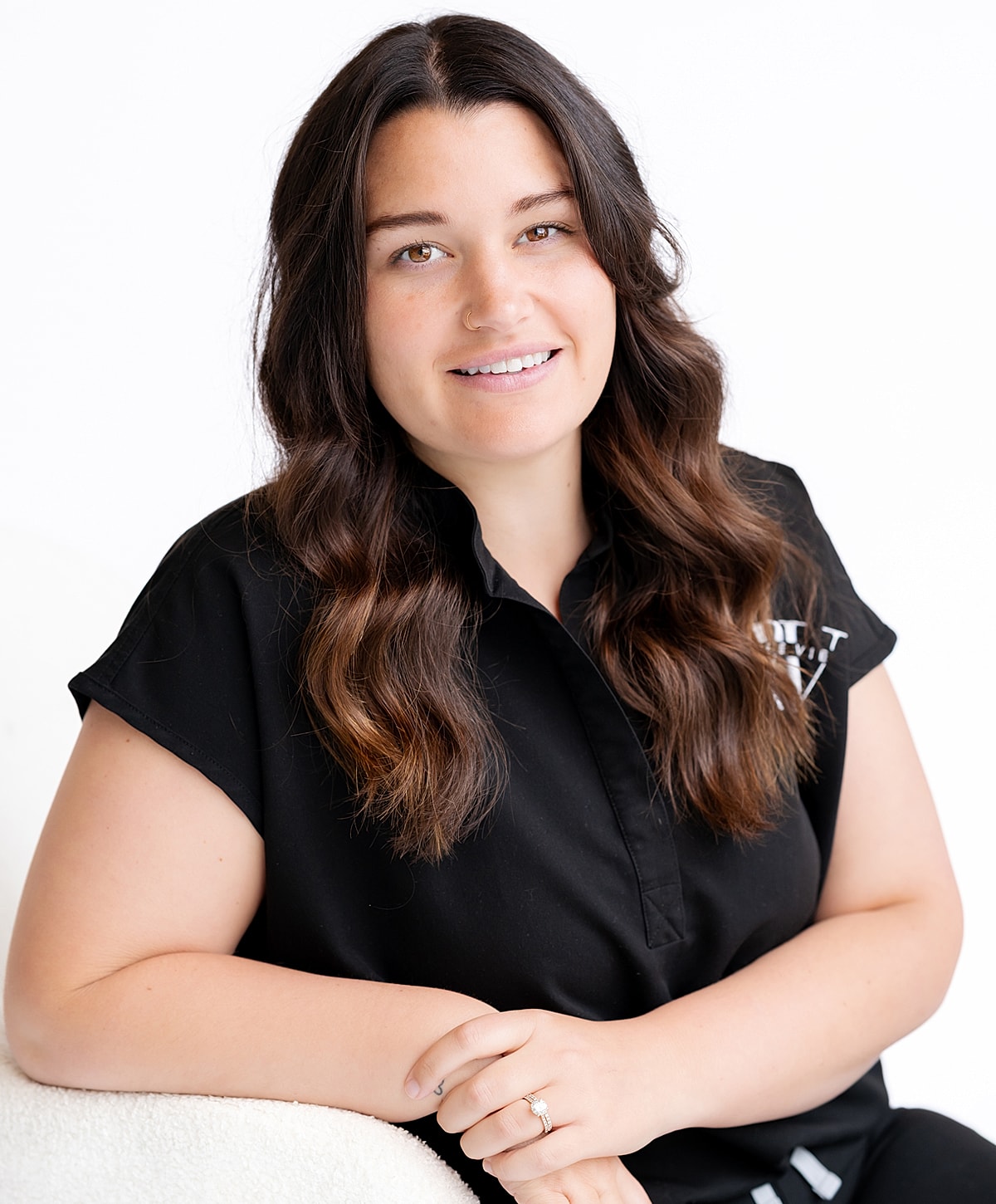 Smiling woman in a black shirt, sitting.
