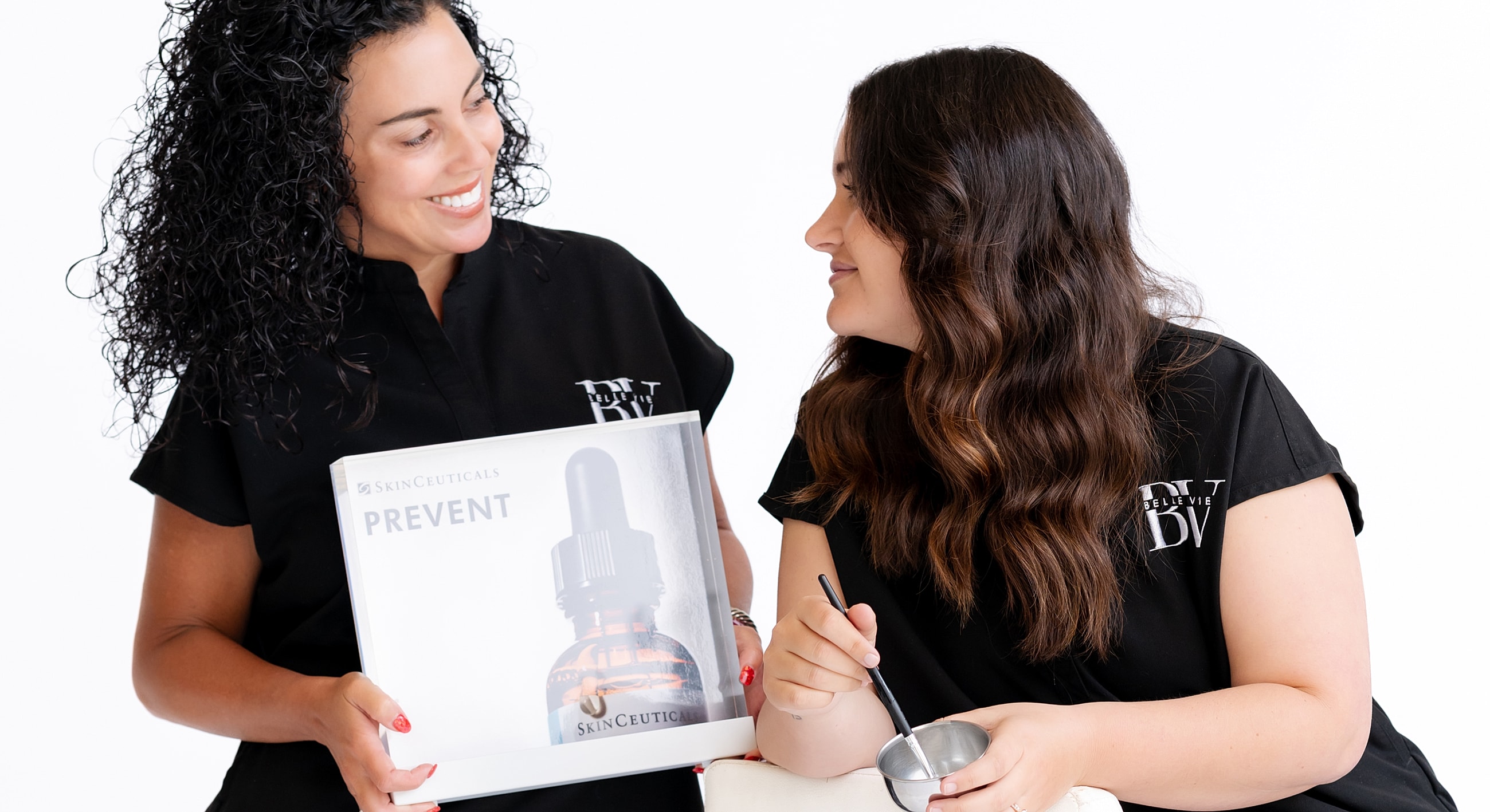 Two women discussing SkinCeuticals skincare product.