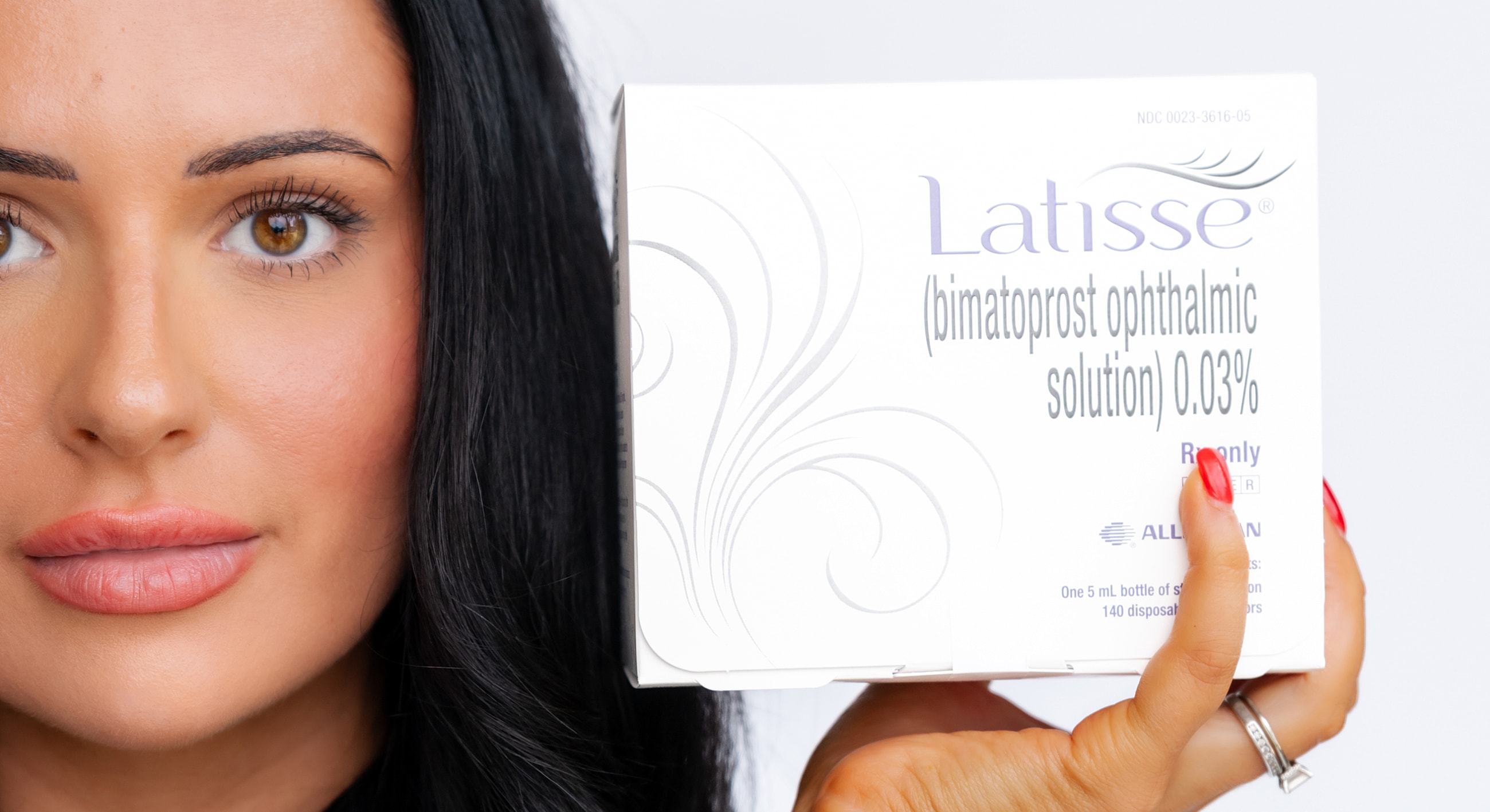 Woman holding Latisse eyelash growth treatment box.