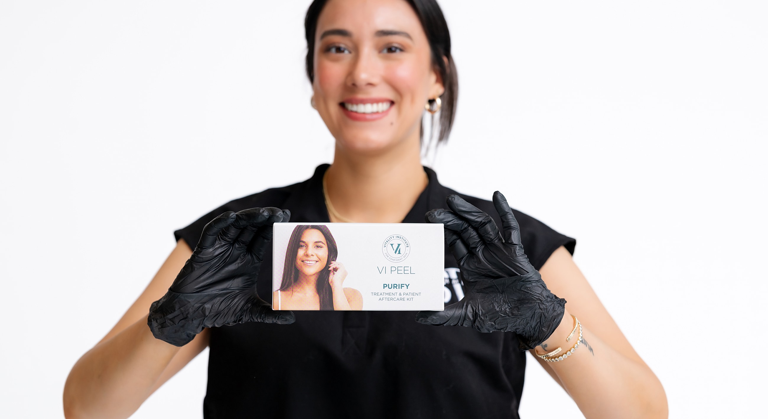 Woman holding VI Peel treatment kit, smiling.